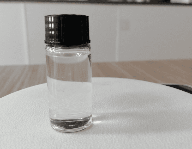 A clear glass bottle filled with high-purity Huachem Dimethyl Isosorbide, showcasing its clear, oily liquid texture and premium packaging for stability.